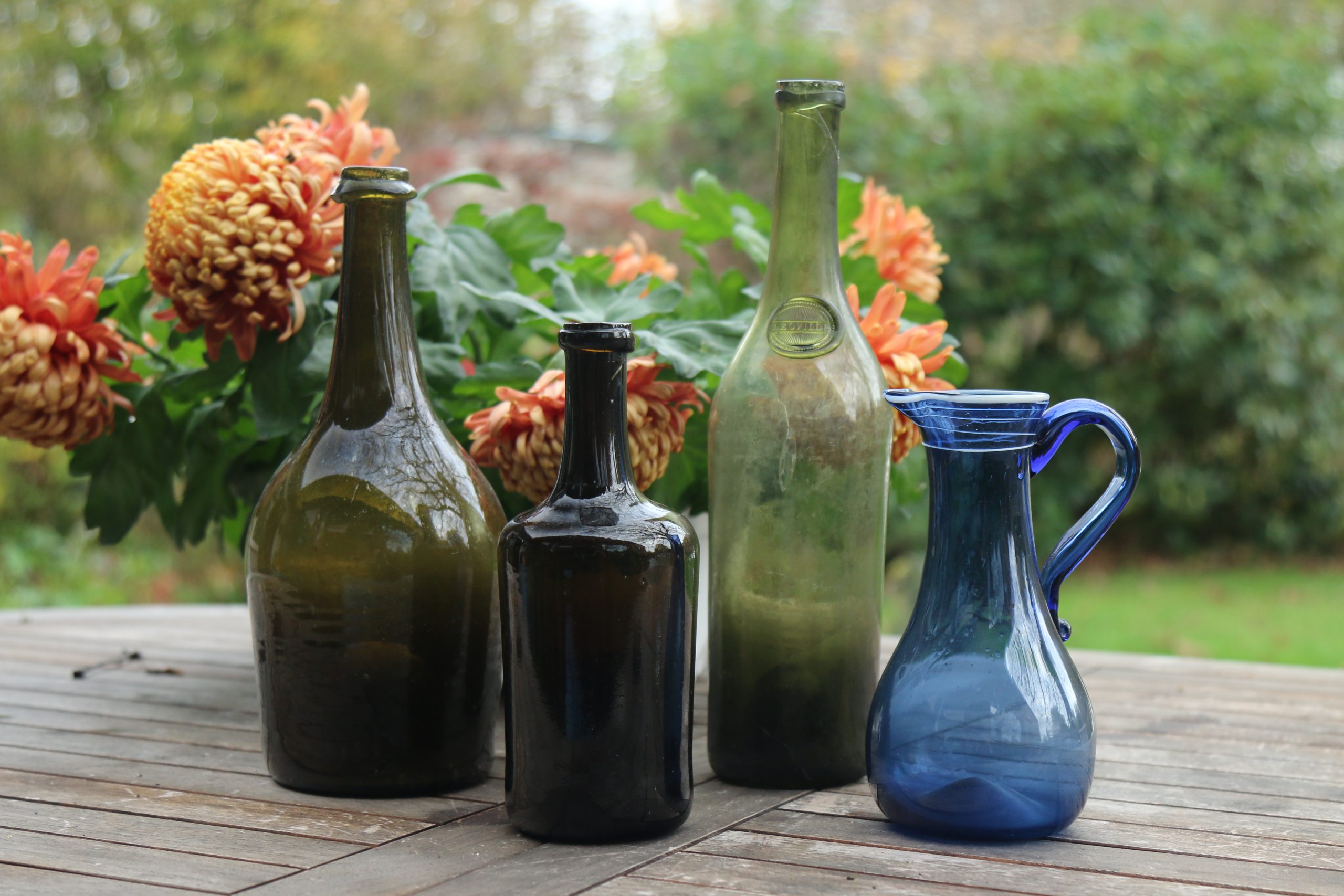 Trois bouteilles anciennes et un pichet